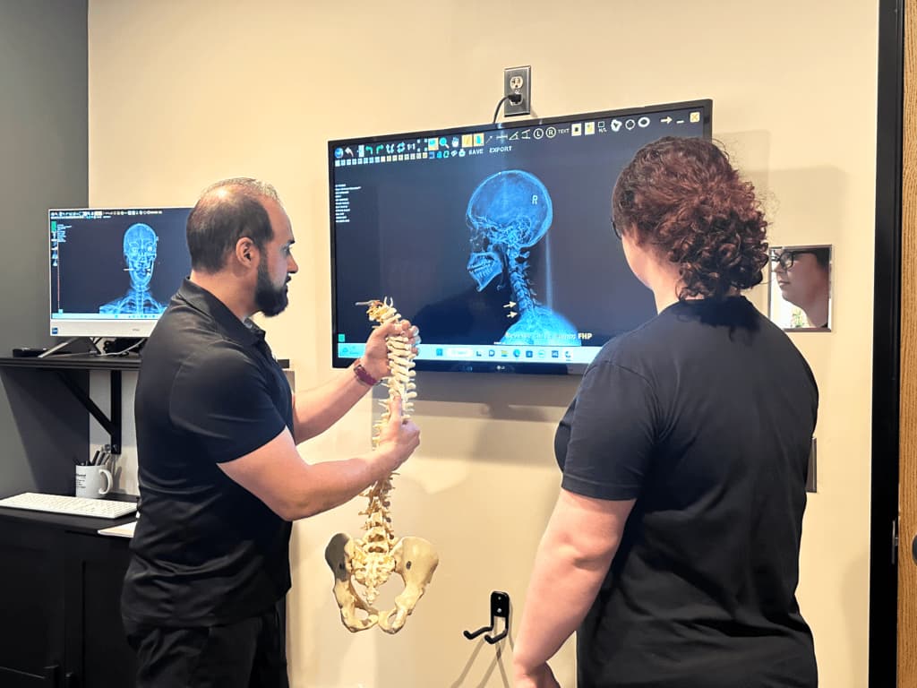 HealthSource doctor reviewing spine model and imaging with a patient